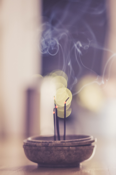Smoking and smelling joss sticks at home, feng shui; Copy space